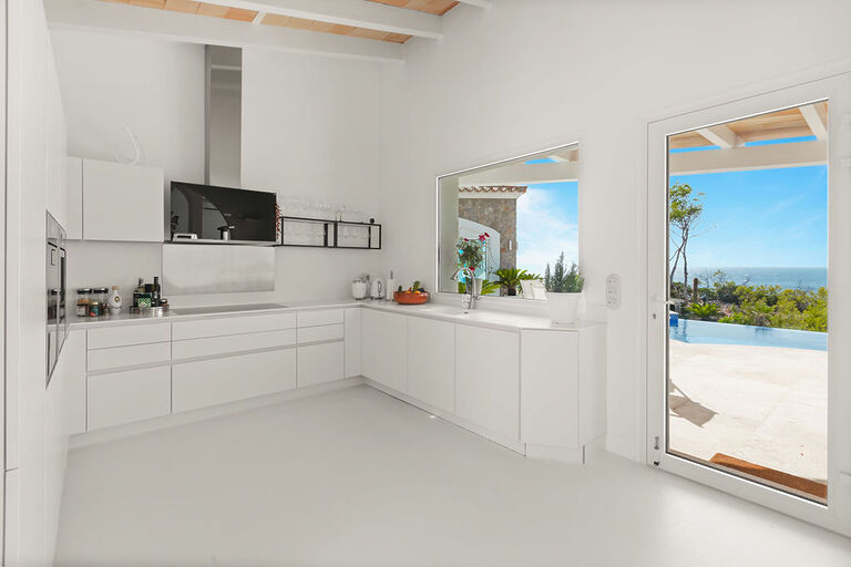 Villa in Port Andratx - Moderne, in weiß gehaltene Küche mit Zugang zur Terrasse